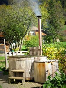 a wooden bench sitting next to a fountain in a garden at Chalet trappeur in Le Biot