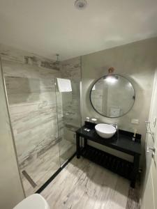 y baño con lavabo y espejo. en Glo apart hotel en Cañuelas