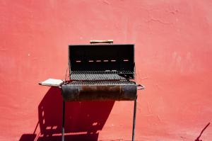 a grill sitting on top of a red wall at Cabañas Antay, antes Casa Kirckir in San Pedro de Atacama