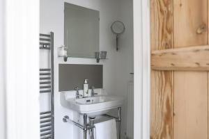 Coombers Mead Cottage في تيتبري: حمام مع حوض ومرآة +29 صورة