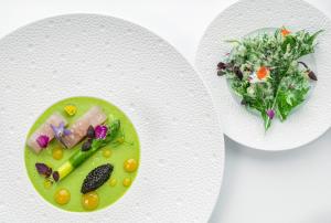 um prato de comida e uma salada numa mesa em Hôtel & Spa Le Grand Large em Dolus