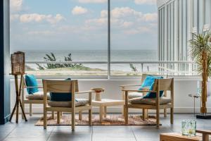 a room with chairs and a view of the ocean at Hôtel & Spa Le Grand Large in Dolus-d'Oléron
