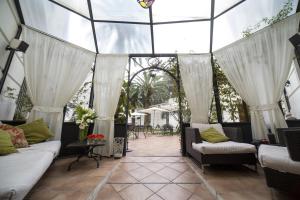 a conservatory with white curtains and a glass ceiling at Villa Imperiale Hotel in Spotorno