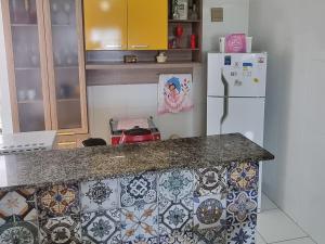 uma cozinha com uma bancada e um frigorífico em Apartamento Vila Aconchego Vermelho em Salvador