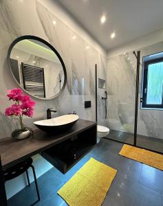 a bathroom with a sink and a large mirror at Luxury Apartments Keszthely in Keszthely
