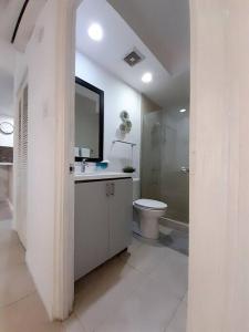 a white bathroom with a toilet and a sink at Choose To Be Happy at Brompton Estates - One and Two Bedroom with Pool in Kingston