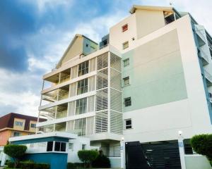 a tall white apartment building with at Choose To Be Happy at Brompton Estates - One and Two Bedroom with Pool in Kingston