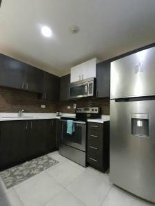 a kitchen with stainless steel appliances and black cabinets at Choose To Be Happy at Brompton Estates - One and Two Bedroom with Pool in Kingston