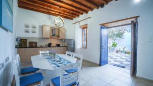 a kitchen and dining room with a white table and chairs at Villa Niki in Loutro