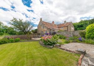 an old house with a garden in front of it at Stoneleigh in Hutton le Hole