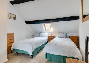 two beds in a room with white walls at Storm Cottage in Robin Hood's Bay