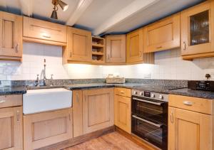 a kitchen with wooden cabinets and a sink at Storm Cottage in Robin Hood's Bay