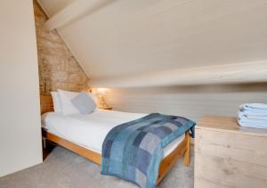 een kleine slaapkamer met een bed en een houten dressoir bij Storm Cottage in Robin Hood's Bay