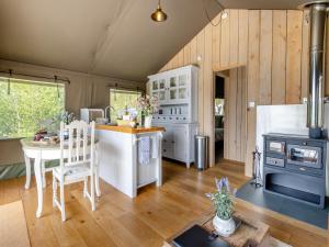 a kitchen and living room with a stove and a table at Bluebell - Uk43602 in Llangyniew