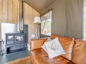 a leather couch in a living room with a wood stove at Bluebell - Uk43602 in Llangyniew
