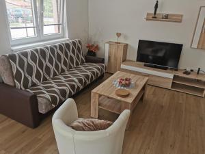 uma sala de estar com um sofá e uma mesa em Apartmány Svítkov 79 em Pardubice