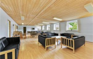 a living room with black leather furniture and wooden ceilings at Cozy Home In Løkken With Kitchen in Lønstrup +44 photos