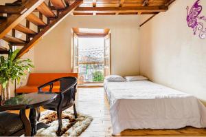 1 dormitorio con cama, mesa y ventana en Hostal La Suite, en Sangolquí