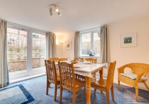 - une salle à manger avec une table, des chaises et des fenêtres dans l'établissement Starlight Cottage, à Whitby