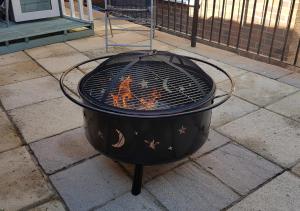 un foyer extérieur sur un trottoir avec barbecue dans l'établissement Starlight Cottage, à Whitby