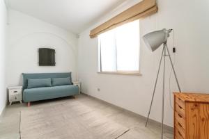 a living room with a blue couch and a window at Privilege Casa da Videira with Swimming Pool, Quelfes - Olhão in Olhão