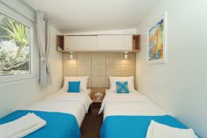 two beds in a small room with a window at Holiday Home Artina 1 in Lovište