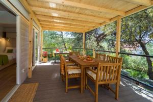 a patio with a wooden table and chairs on a deck at Holiday Home Artina 1 in Lovište