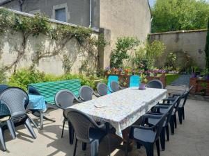 una mesa y sillas en un patio con mesa y sillón en Maison Violette en Berry, en Aigurande