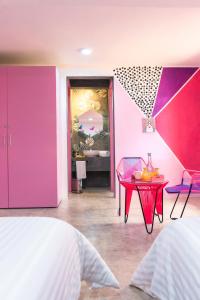- une chambre avec des murs roses et violets et une table dans l'établissement Hotel Suculenta Boutique, à San Cristóbal de Las Casas