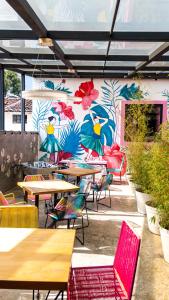 un restaurant avec des tables et des chaises et un mur fleuri dans l'établissement Hotel Suculenta Boutique, à San Cristóbal de Las Casas