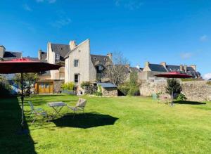 podwórze z krzesłami i stołami przed dużym domem w obiekcie Appartement Bollyroom - Plage 50m - Rue gratuite w Saint-Malo