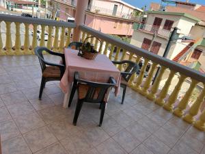 a table and chairs sitting on a balcony at Silver rooms in La Caletta