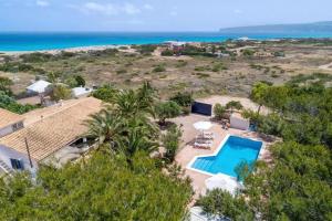 an aerial view of a house with a swimming pool and the ocean at Xaloc in Es Calo