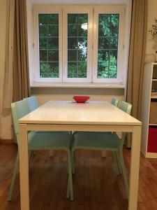 a table with chairs and a red bowl on top at Pasarét Apartman in Budapest