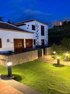 a white house with lights in a yard at night at Hotel Rural Casablanca in Los Realejos +41 photos