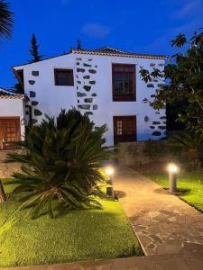 une maison blanche avec des lumières devant elle dans l'établissement Hotel Rural Casablanca, à Los Realejos