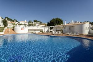a large swimming pool in front of a house at NEW LISTING - Eden Villas in Vilamoura