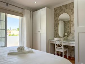 un dormitorio con una cama y un espejo en NEW LISTING - Eden Villas, en Vilamoura 25 fotos más