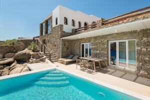 eine Villa mit Swimmingpool und einem Haus in der Unterkunft Etesians Suites & Villas in Super Paradise Beach