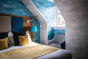 a bedroom with a bed and a blue wall at Duisdale House Hotel in Isleornsay