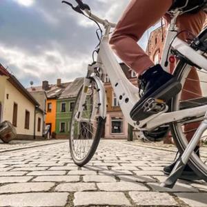 a person riding a bike on a cobblestone street at SPREE. Hotel am Hafen in Lübbenau