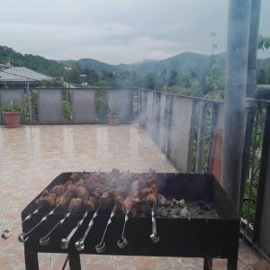 a grill with meat on it on a patio at Belas House With Terrace in Kutaisi