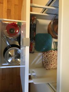 a cupboard with a stack of dishes and aroll at Pasarét Apartman in Budapest