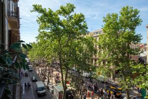 a busy street in a city with pedestrians and cars at Standbyme Ramblas in Barcelona