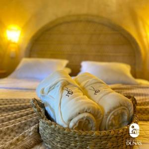 a basket of folded towels sitting on a bed at Pousada Rancho das Dunas in Santo Amaro