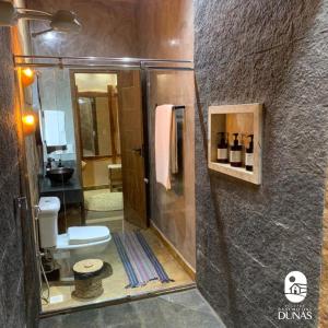 uma casa de banho com um chuveiro, um WC e um lavatório. em Pousada Rancho das Dunas em Santo Amaro
