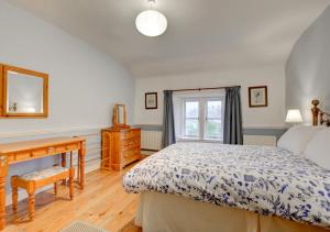 a bedroom with a bed and a desk and a window at South View Cottage in Horton in Ribblesdale