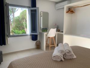 a bedroom with towels on a bed with a window at Villa NanSea in Kastraki +40 photos