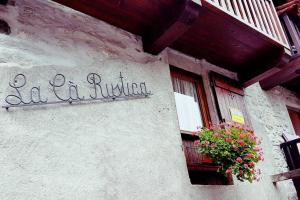 a sign on the side of a building with a window at La Cà Rustica - casa vacanze in Bognanco