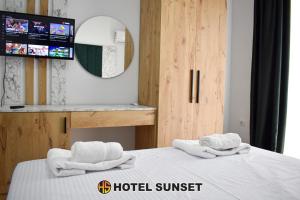 duas toalhas numa cama numa suite de hotel em Hotel SUNSET Shengjin em Shëngjin